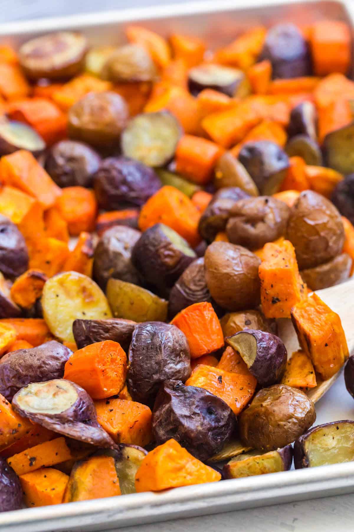 Roasted root vegetables on a sheet pan.