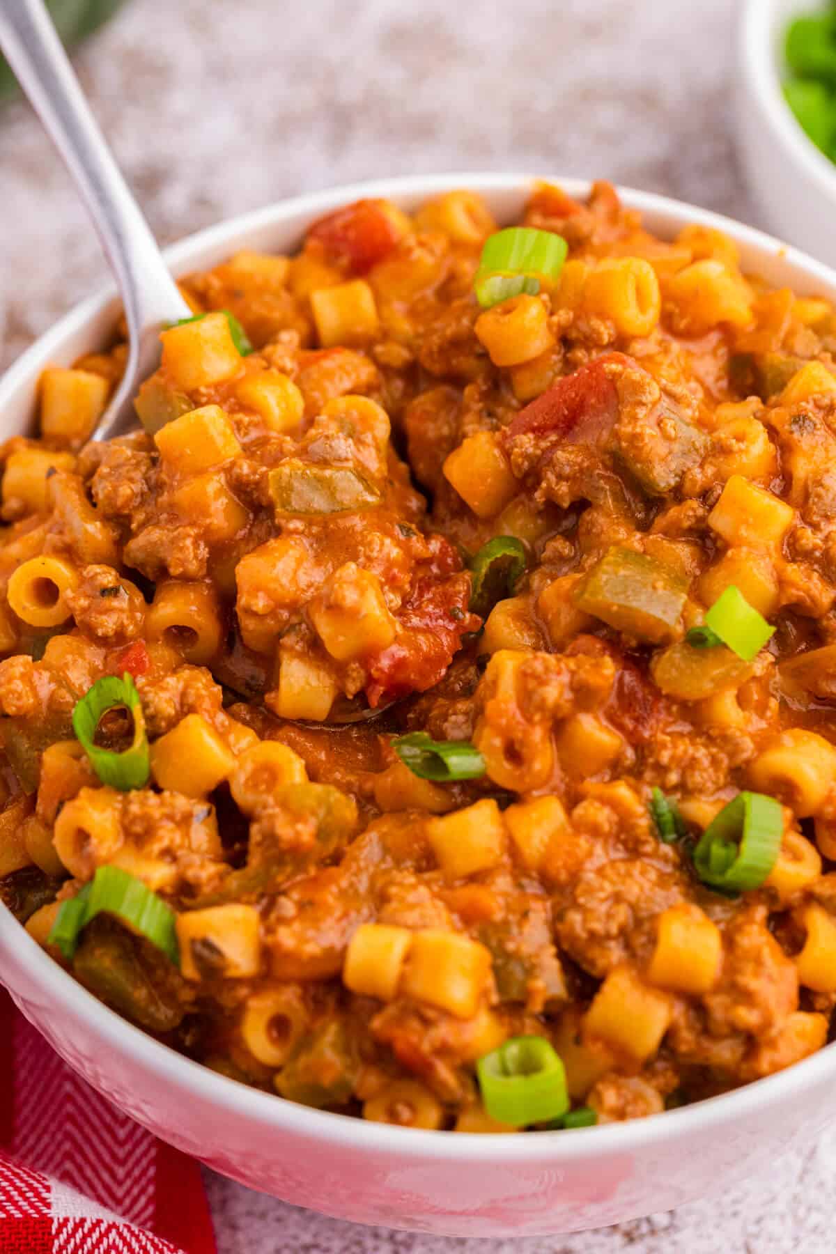 A spoon in a bowl of unstuffed pepper pasta.