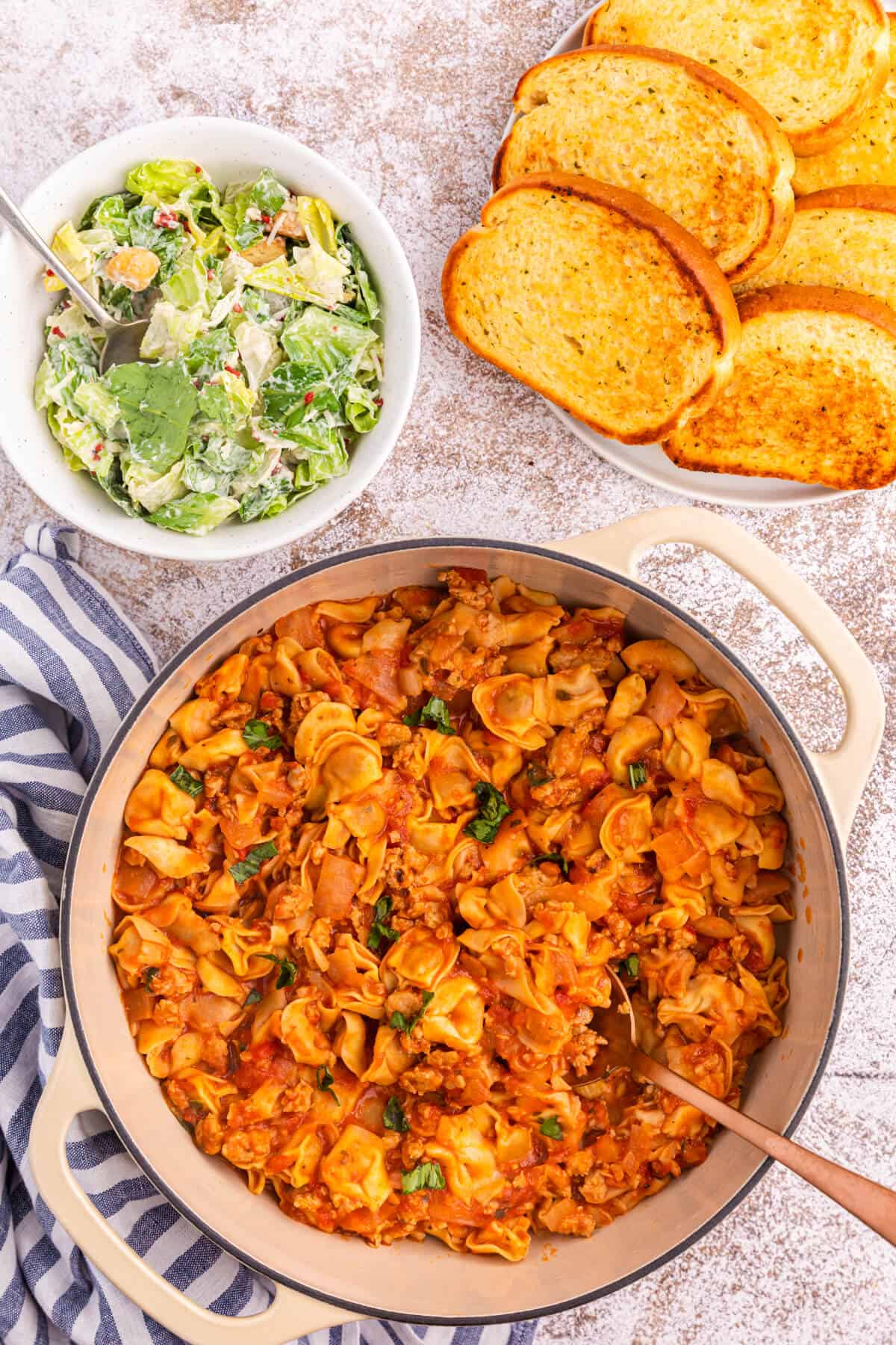 A dutch oven filled with sausage and cheese cappelletti.