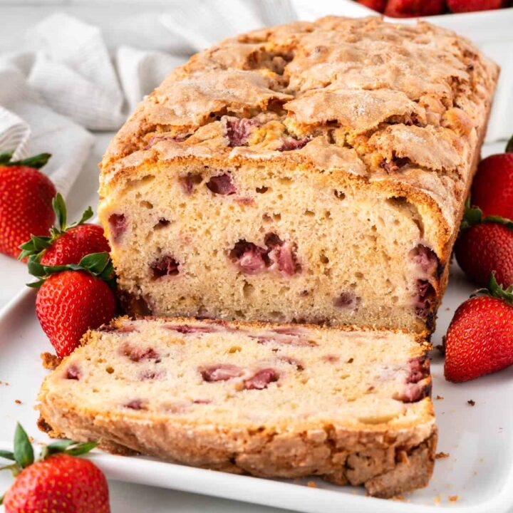 Strawberry bread with slices cut off on a platter.