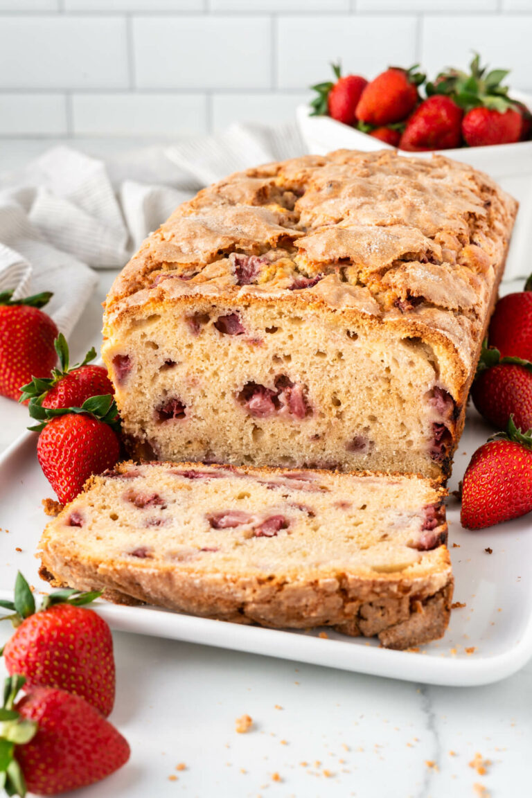 Strawberry bread with slices cut off on a platter.