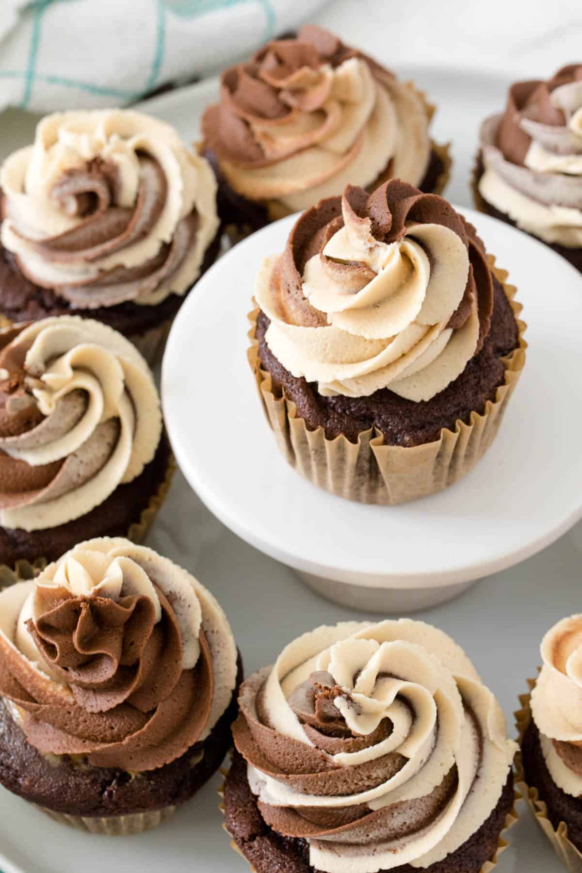 chocolate peanut cupcakes surrounding a cupcake on a cupcake stand