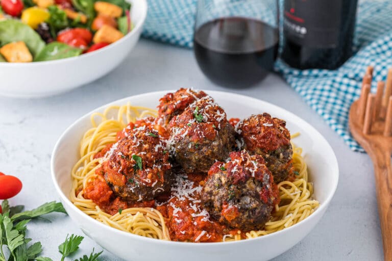 Cheesy meatballs and spaghetti in a bowl.
