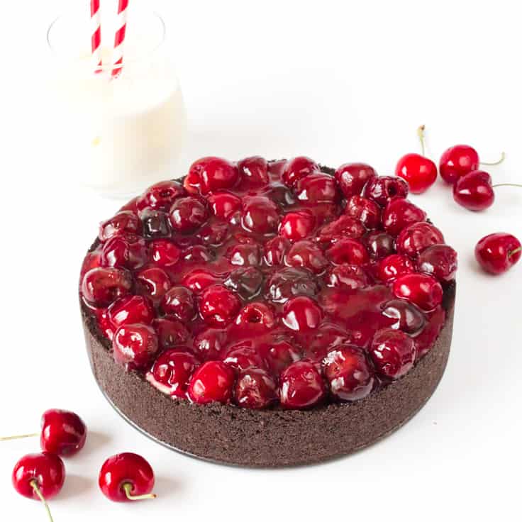 Cherry Cheesecake with Oreo Crust - Chocolate and cherry combine for this decadent dessert! The sweet cheesecake filling melds perfectly with the crunchy cookie crust for a delicious and beautiful treat.