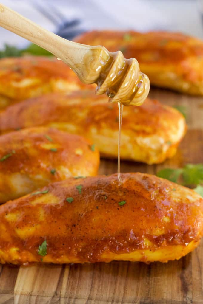 Honey being drizzled on the chicken.