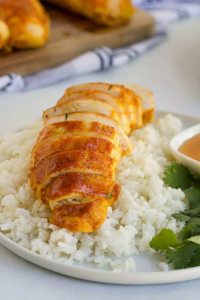 Sliced chicken breast on a bed of white rice.