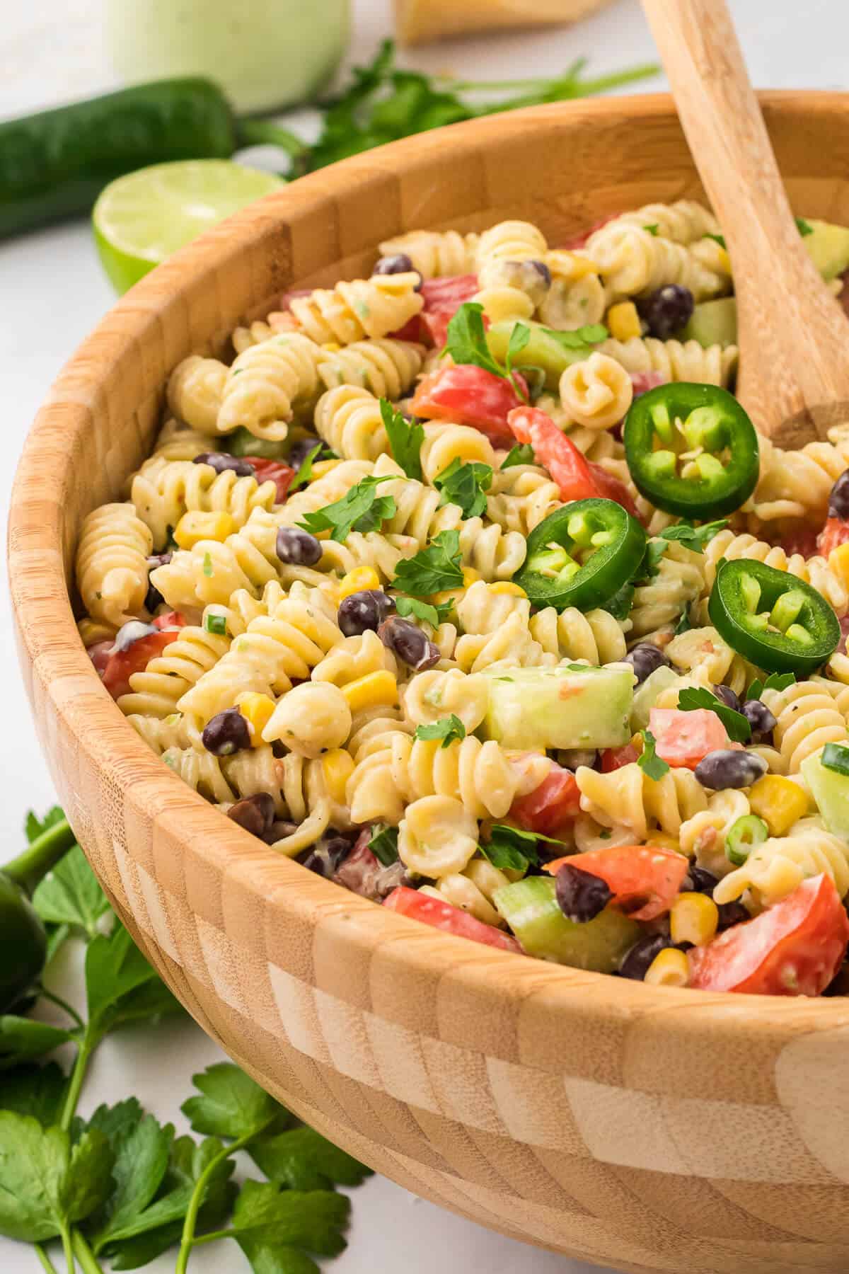 A wooden bowl with jalapeno ranch pasta salad.