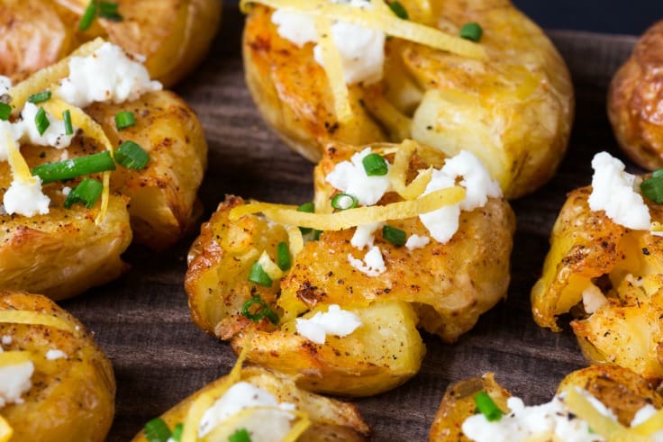 Smashed Potatoes with Lemon, Garlic, and Feta - This easy potato side dish is crunchy on the outside and fluffy on the inside! Topped with lemon zest, crumbled feta cheese, and smoked paprika.