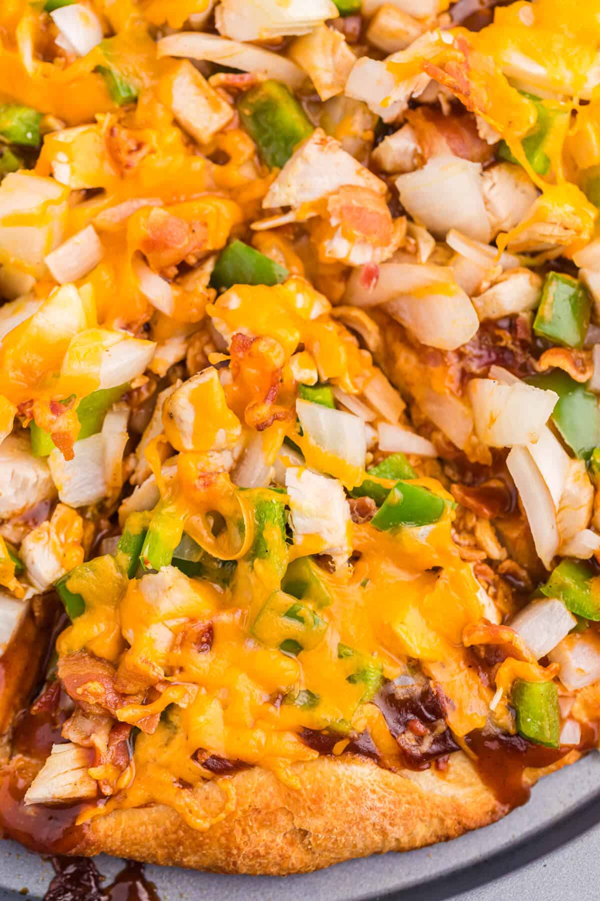 Close up of a slice of BBQ Chicken Pizza on a baking sheet.