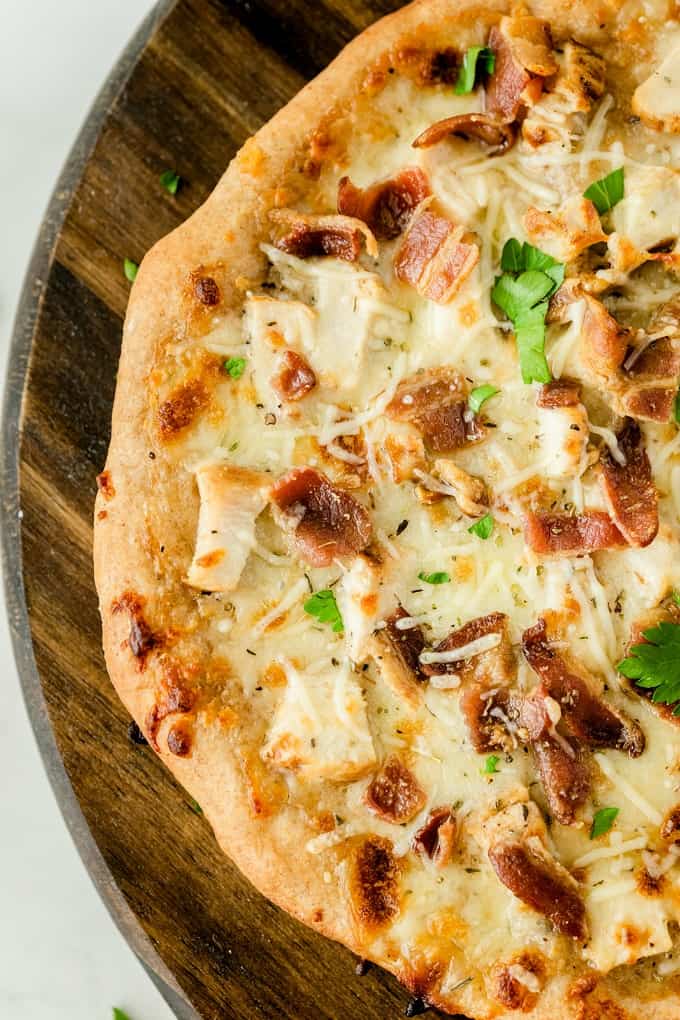 Chicken Caesar Pizza - Your favorite salad can also be your favorite homemade pizza recipe! Ditch the lettuce and make this simple crowdpleaser. Imagine pizza crust smothered in creamy Caesar dressing, topped with bacon, chicken and cheese!