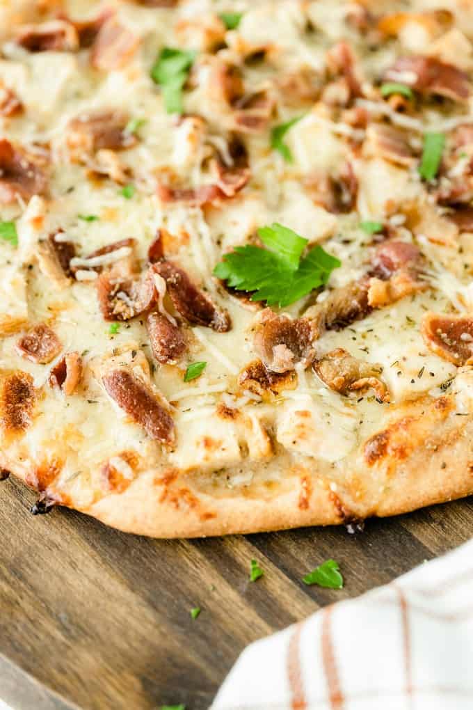 Chicken Caesar Pizza - Your favorite salad can also be your favorite homemade pizza recipe! Ditch the lettuce and make this simple crowdpleaser. Imagine pizza crust smothered in creamy Caesar dressing, topped with bacon, chicken and cheese!