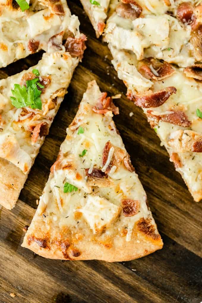 Chicken Caesar Pizza - Your favorite salad can also be your favorite homemade pizza recipe! Ditch the lettuce and make this simple crowdpleaser. Imagine pizza crust smothered in creamy Caesar dressing, topped with bacon, chicken and cheese!