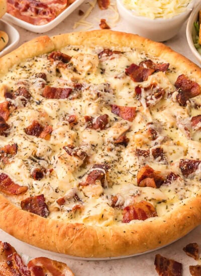 A pizza surrounded by ingredients.