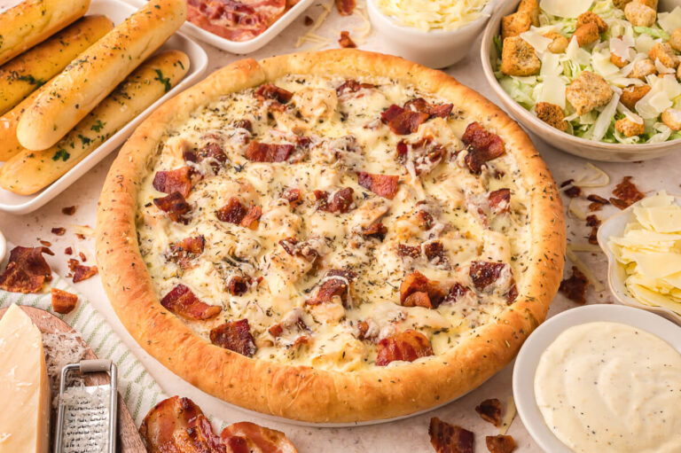 A pizza surrounded by ingredients.