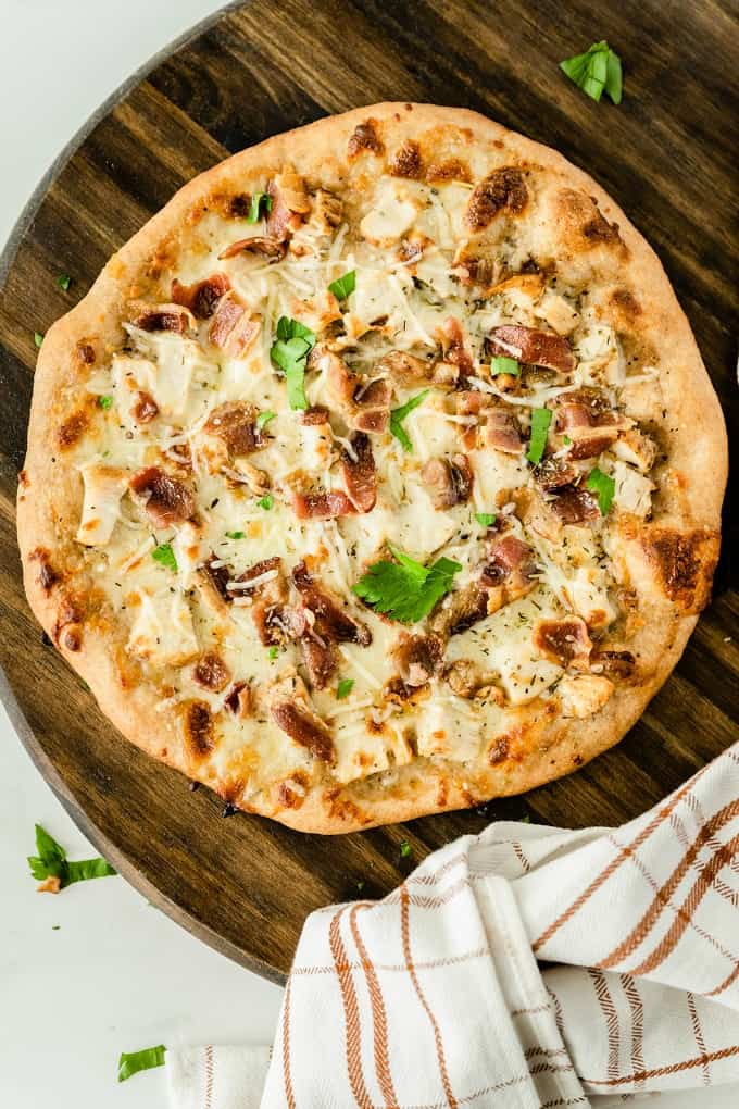 Chicken Caesar Pizza - Your favorite salad can also be your favorite homemade pizza recipe! Ditch the lettuce and make this simple crowdpleaser. Imagine pizza crust smothered in creamy Caesar dressing, topped with bacon, chicken and cheese!