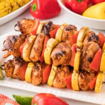 Chipotle chicken skewers on a platter.