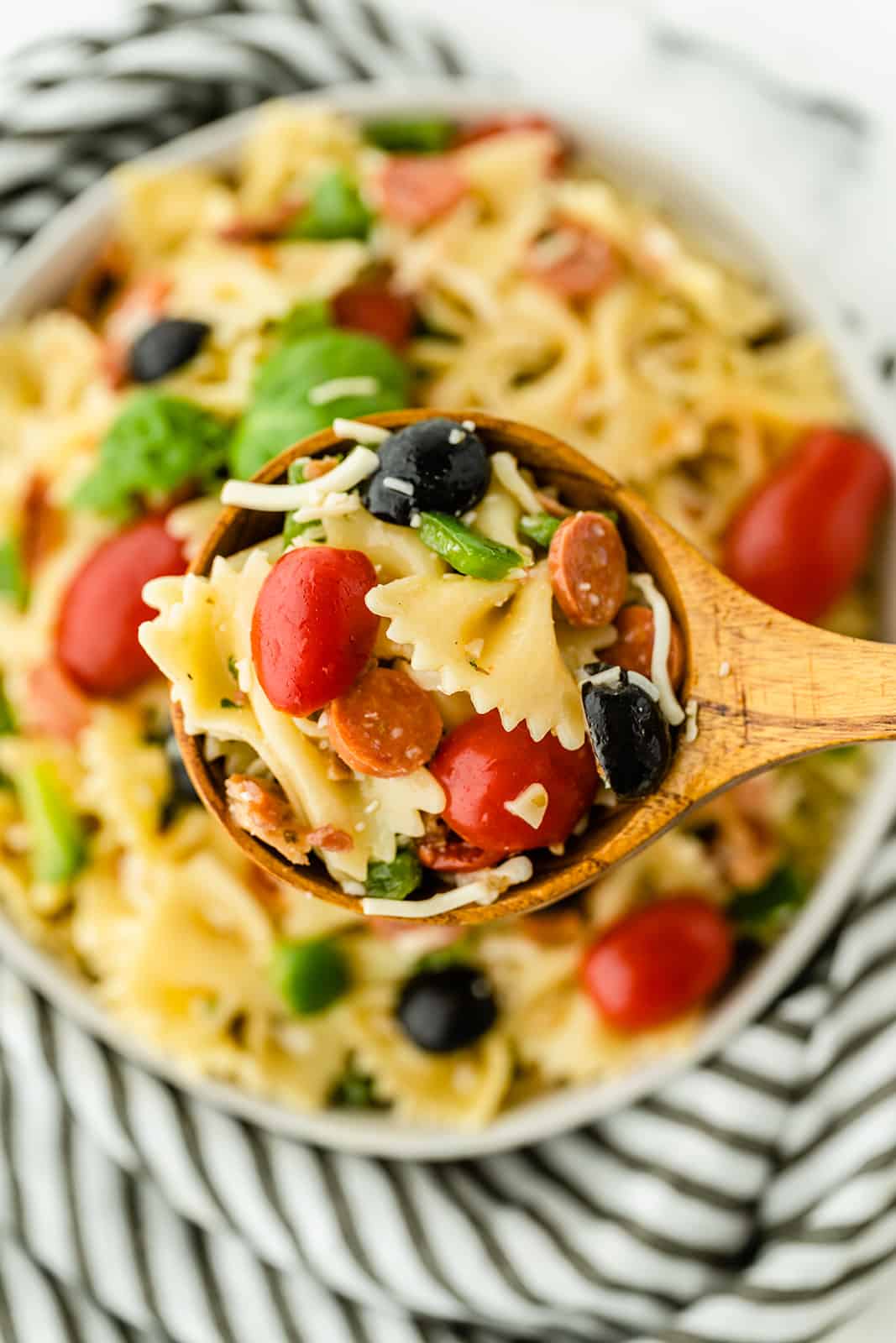 Pizza Pasta Salad - A perfect summer dish with all the best pizza flavors! Salty pepperoni and olives are coated in tangy Italian dressing and covered in cheese.