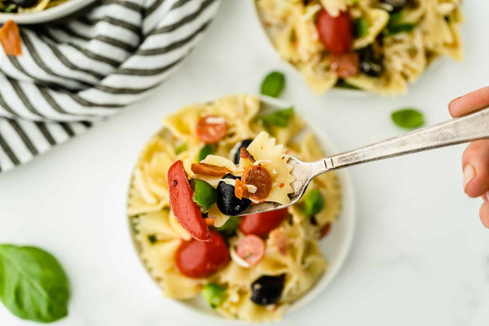 Pizza Pasta Salad - A perfect summer dish with all the best pizza flavors! Salty pepperoni and olives are coated in tangy Italian dressing and covered in cheese.