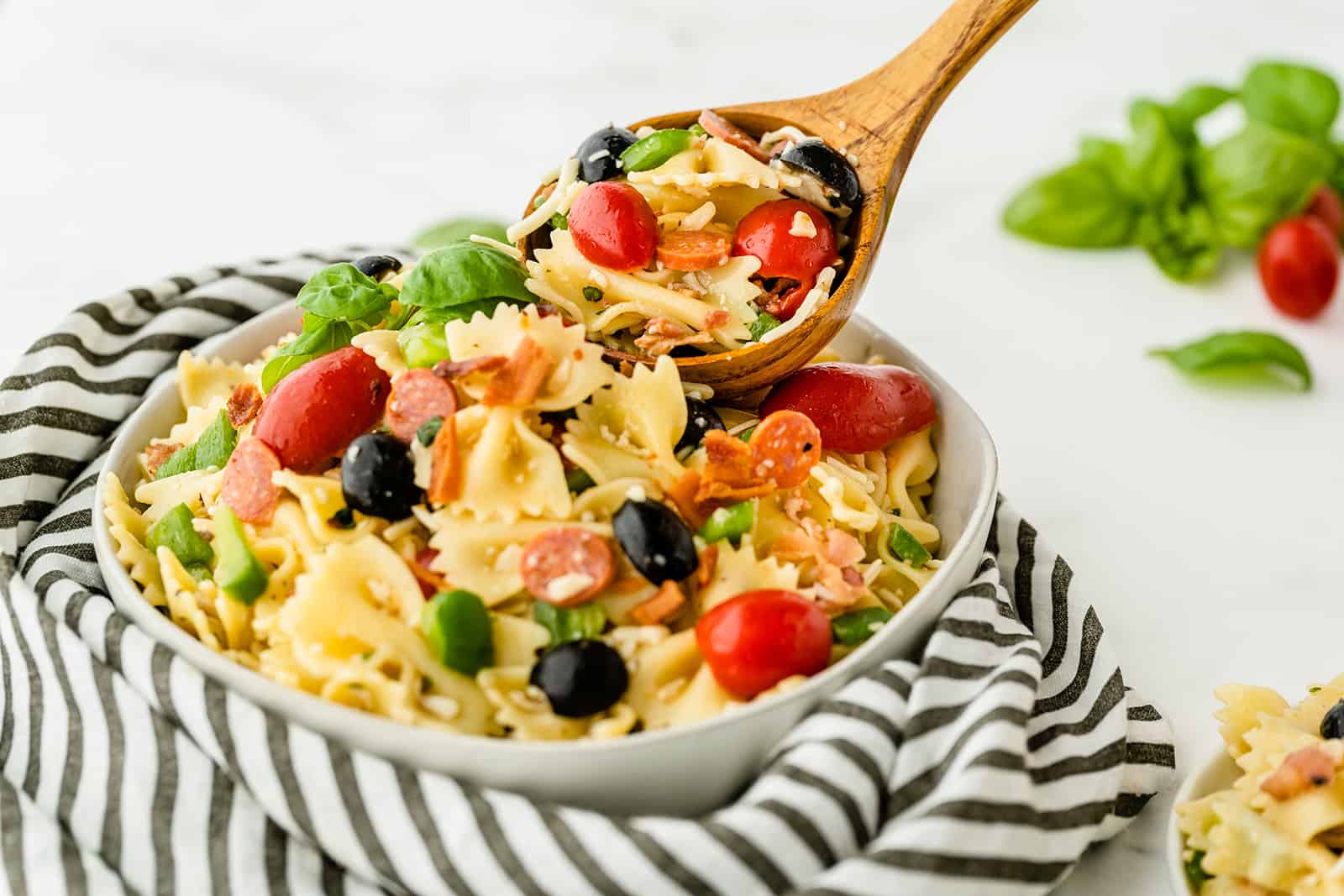 Pizza Pasta Salad - A perfect summer dish with all the best pizza flavors! Salty pepperoni and olives are coated in tangy Italian dressing and covered in cheese.