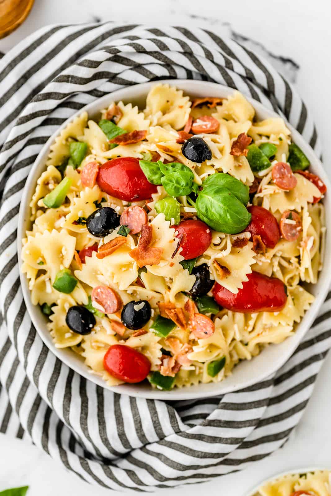 Pizza Pasta Salad - A perfect summer dish with all the best pizza flavors! Salty pepperoni and olives are coated in tangy Italian dressing and covered in cheese.