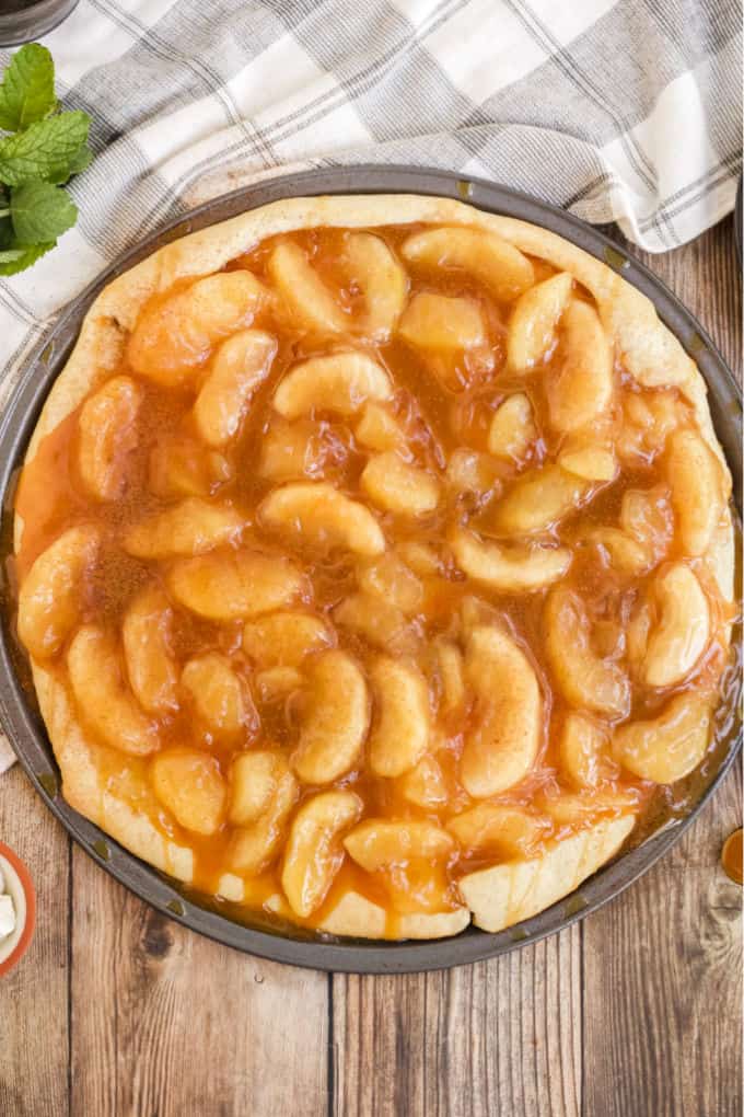 Caramel Apple Pizza - The PERFECT fall dessert pizza! Sweet cinnamon apple pie filling with rich caramel covering a basic pizza crust for the taste of pie without the mess and wait.