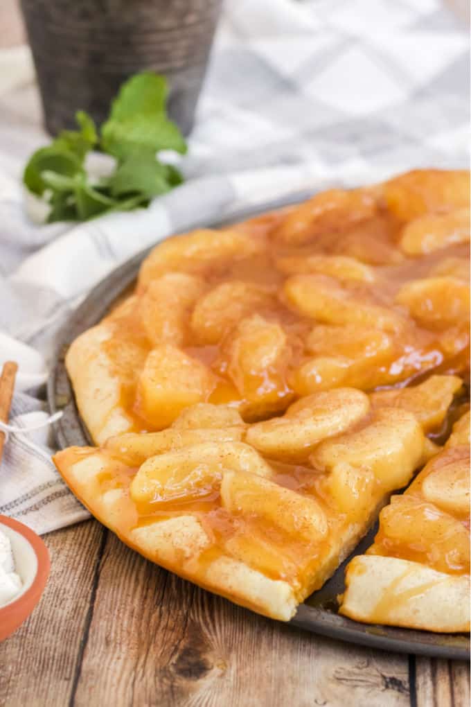 Caramel Apple Pizza - The PERFECT fall dessert pizza! Sweet cinnamon apple pie filling with rich caramel covering a basic pizza crust for the taste of pie without the mess and wait.