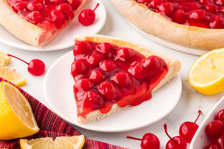 A slice of cherry cheesecake pizza on a plate.
