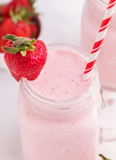 The recipe in a mug with a straw and a strawberry for garnish.