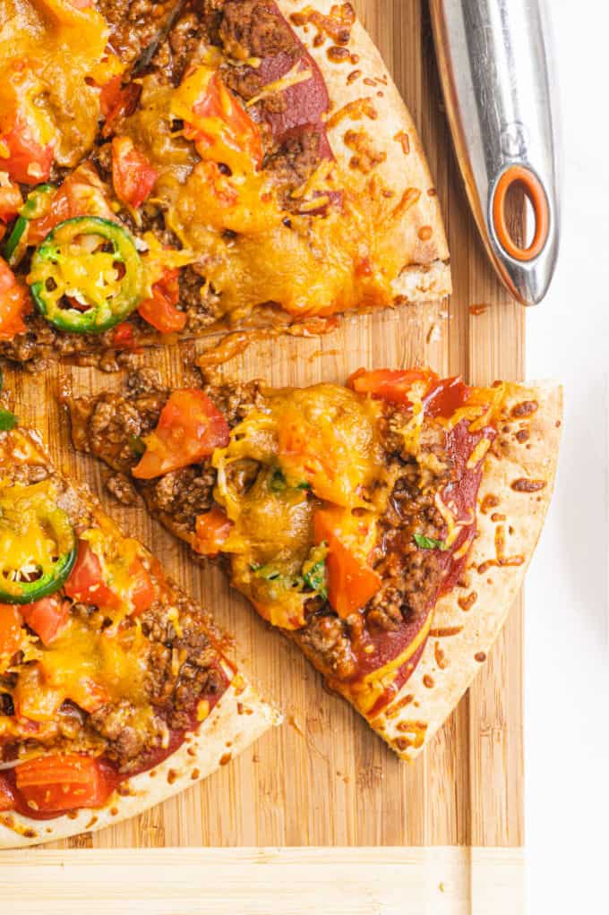 Taco Pizza - Bring Mexican night to your pizzas! Loaded with ground beef, cheese, and tons of veggies, you won't even miss the tortillas.