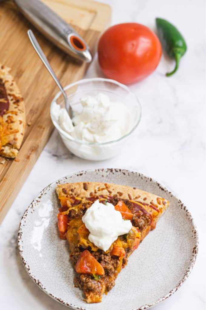 Taco Pizza - Bring Mexican night to your pizzas! Loaded with ground beef, cheese, and tons of veggies, you won't even miss the tortillas.