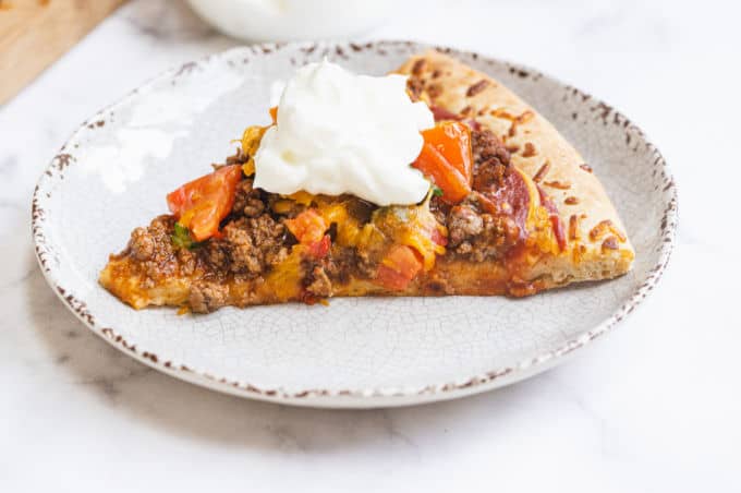 Taco Pizza - Bring Mexican night to your pizzas! Loaded with ground beef, cheese, and tons of veggies, you won't even miss the tortillas.