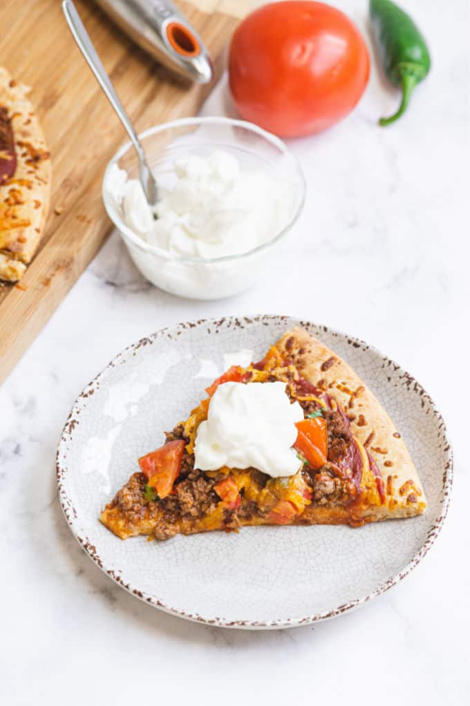 Taco Pizza - Bring Mexican night to your pizzas! Loaded with ground beef, cheese, and tons of veggies, you won't even miss the tortillas.