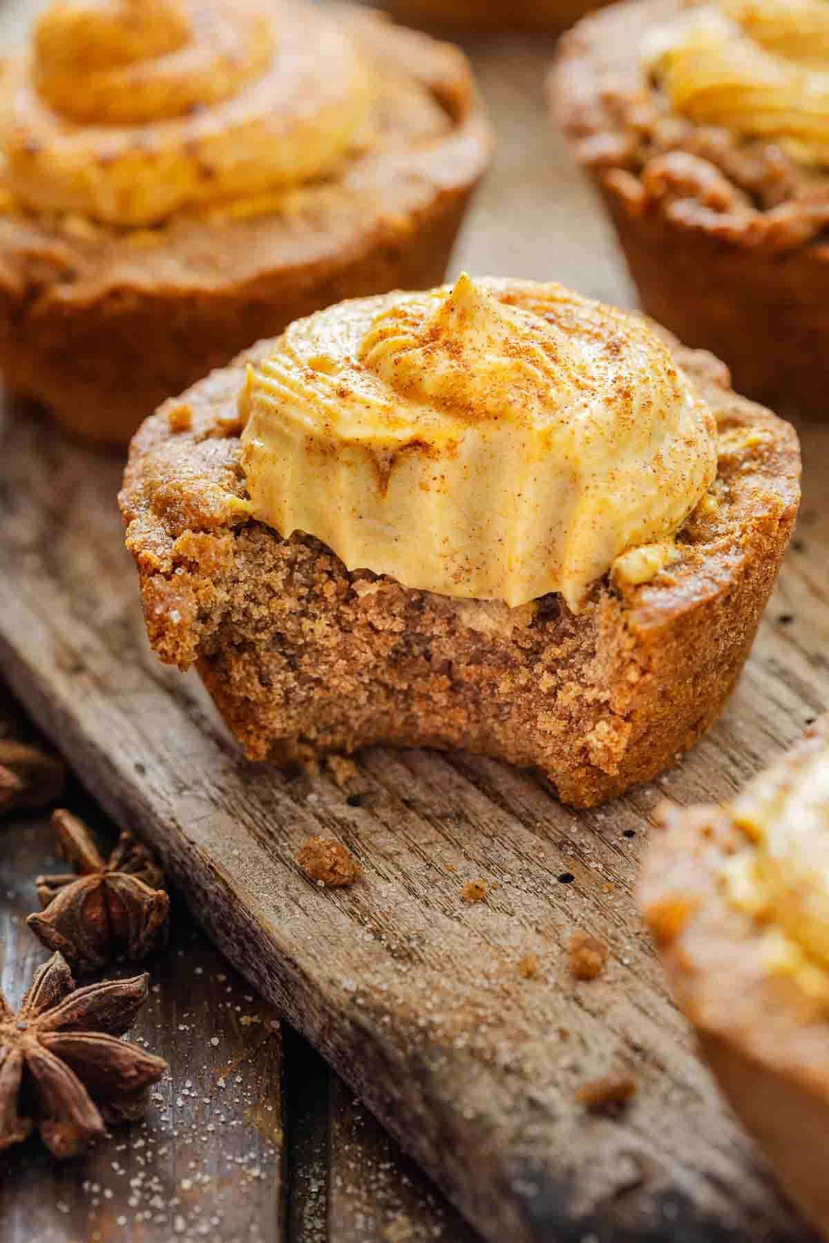 A cake cup with a bite out of it on a wooden surface.
