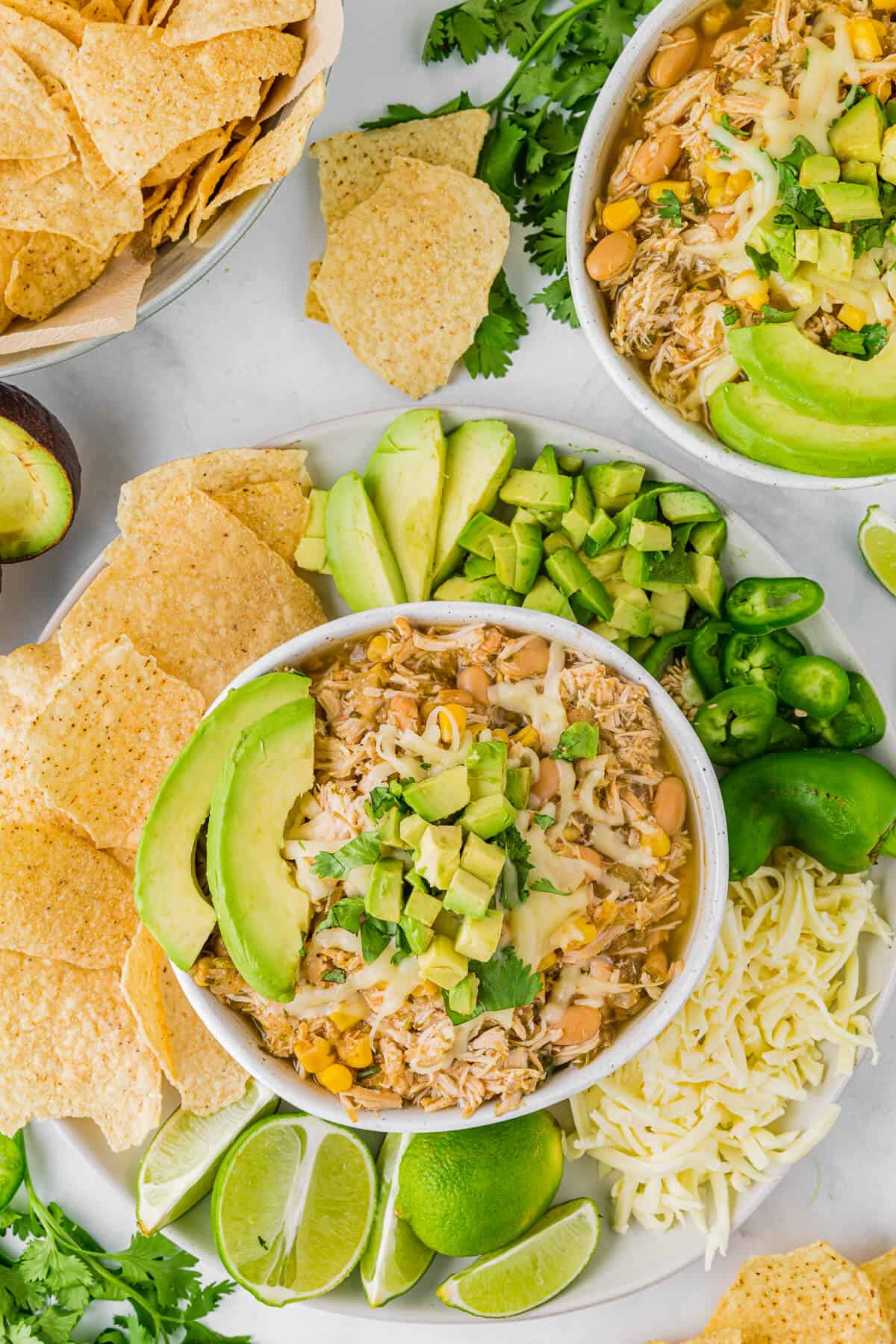 Slow Cooker Verde Chicken Chili in a bowl surrounded by toppings.
