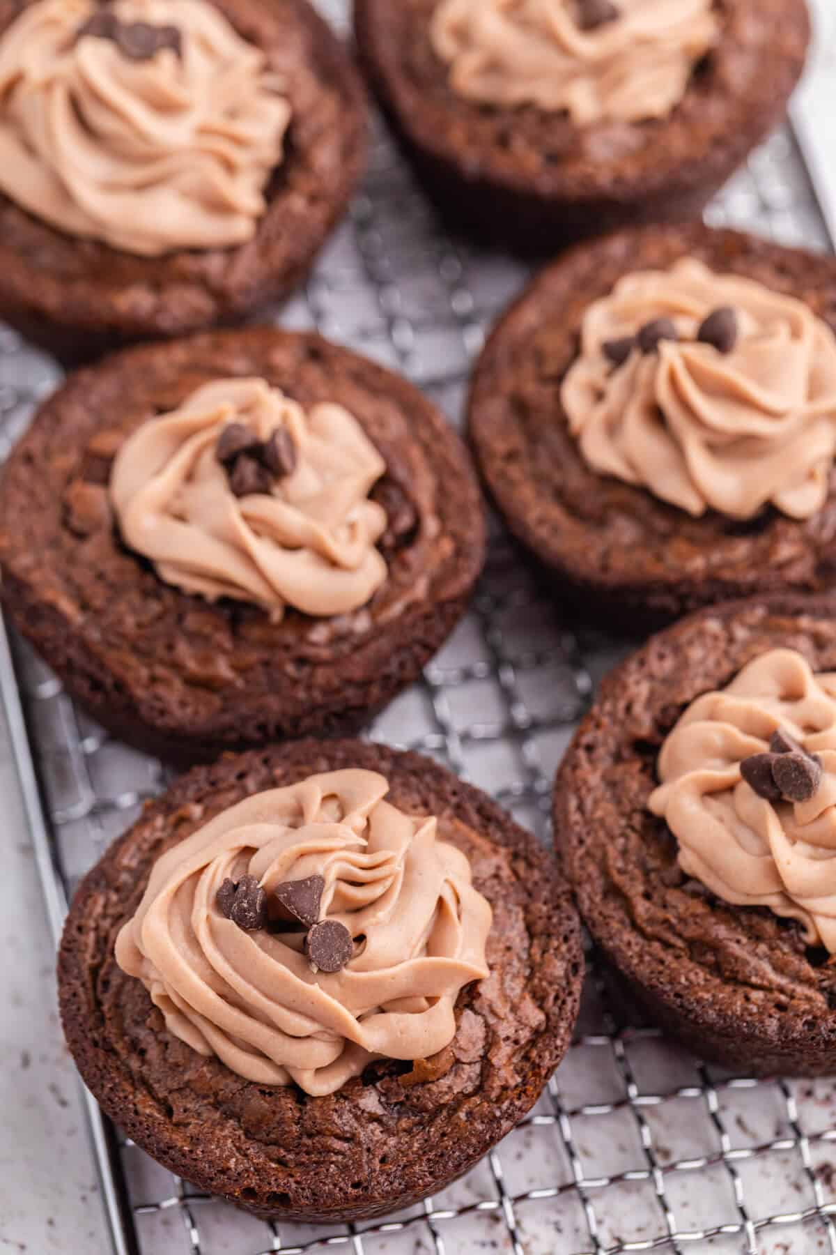 Brownie cheesecake cups on a wire rack.