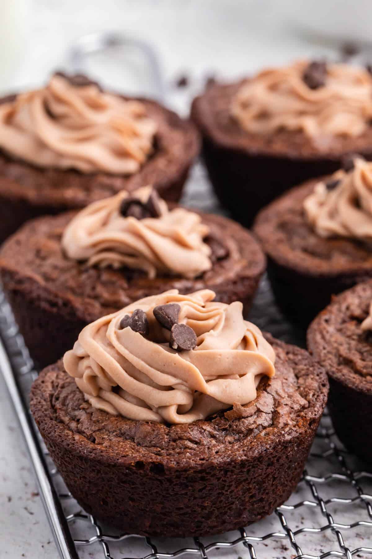 Brownie cheesecake cups on a wire rack.