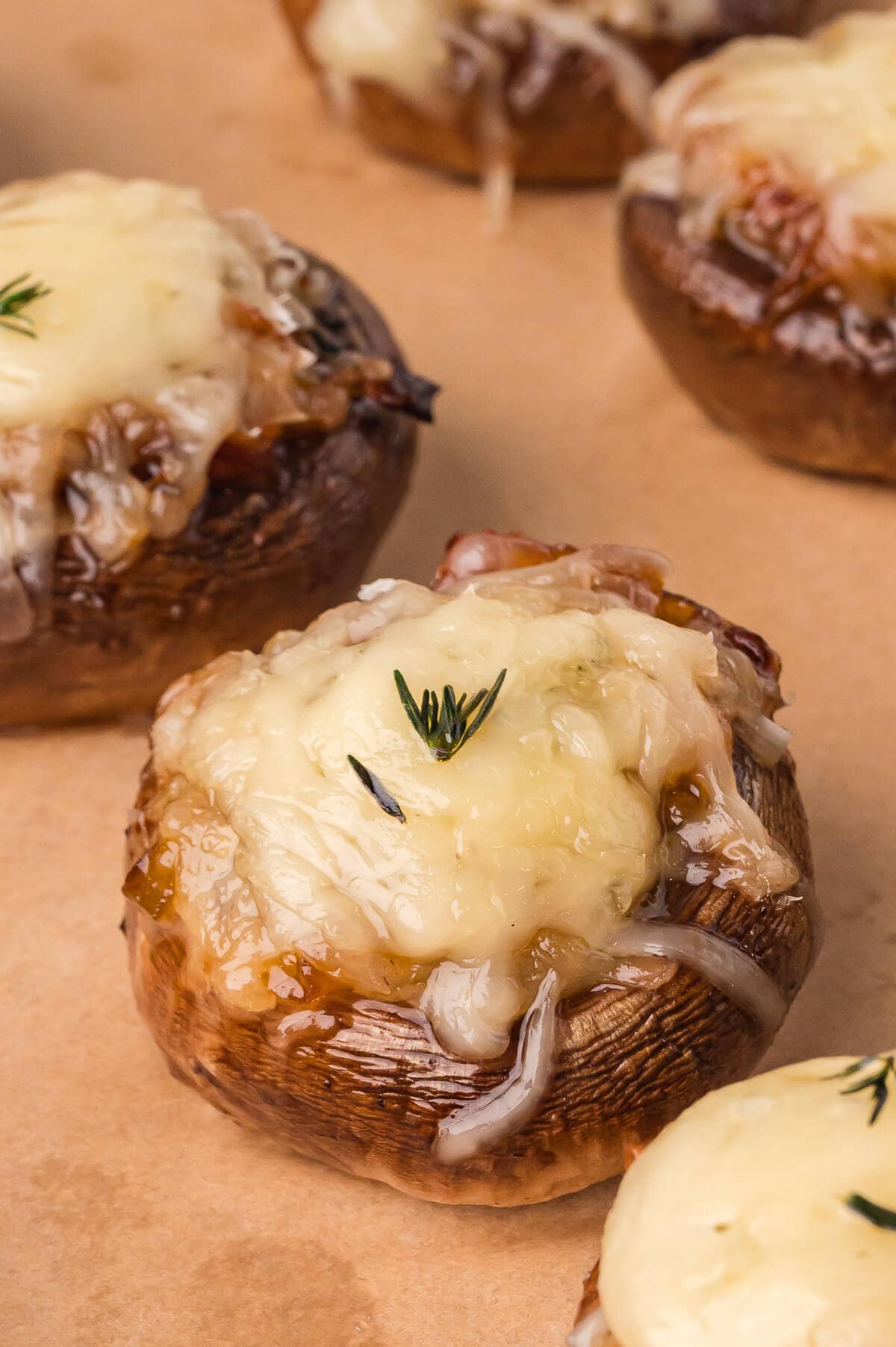 French Onion Stuffed Mushrooms on a brown surface.