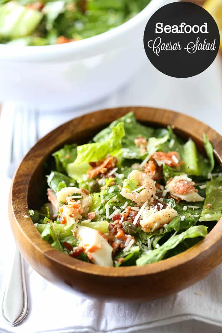 Seafood Caesar Salad Recipe - Elevate your regular dinner salad tonight! Salmon, shrimp, and crab meat are delectable in homemade Caesar dressing and topped with capers and bacon.