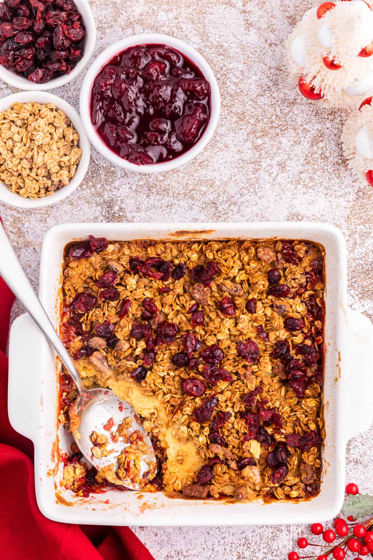 Cranberry Cobbler Dump Cake in a baking pan with a serving spoon.