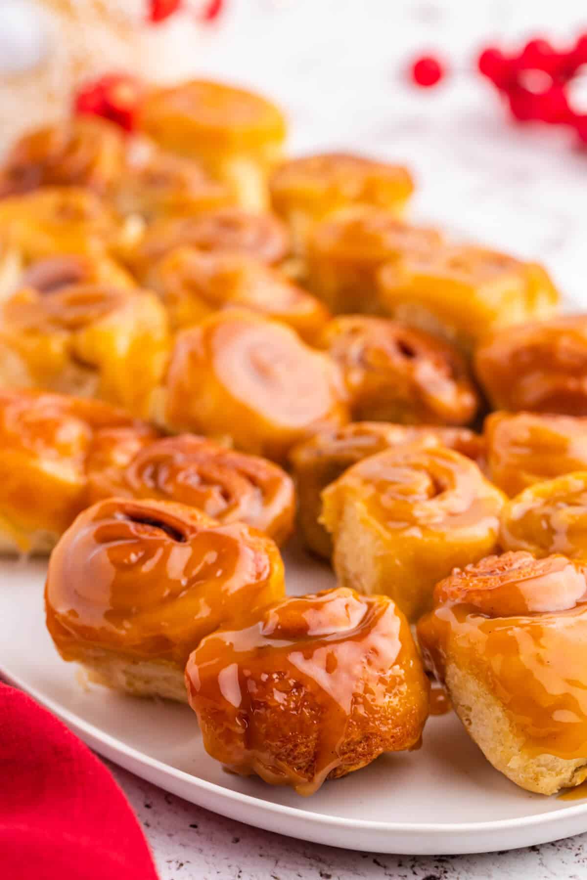 Mini rum butter cinnamon rolls on a platter.