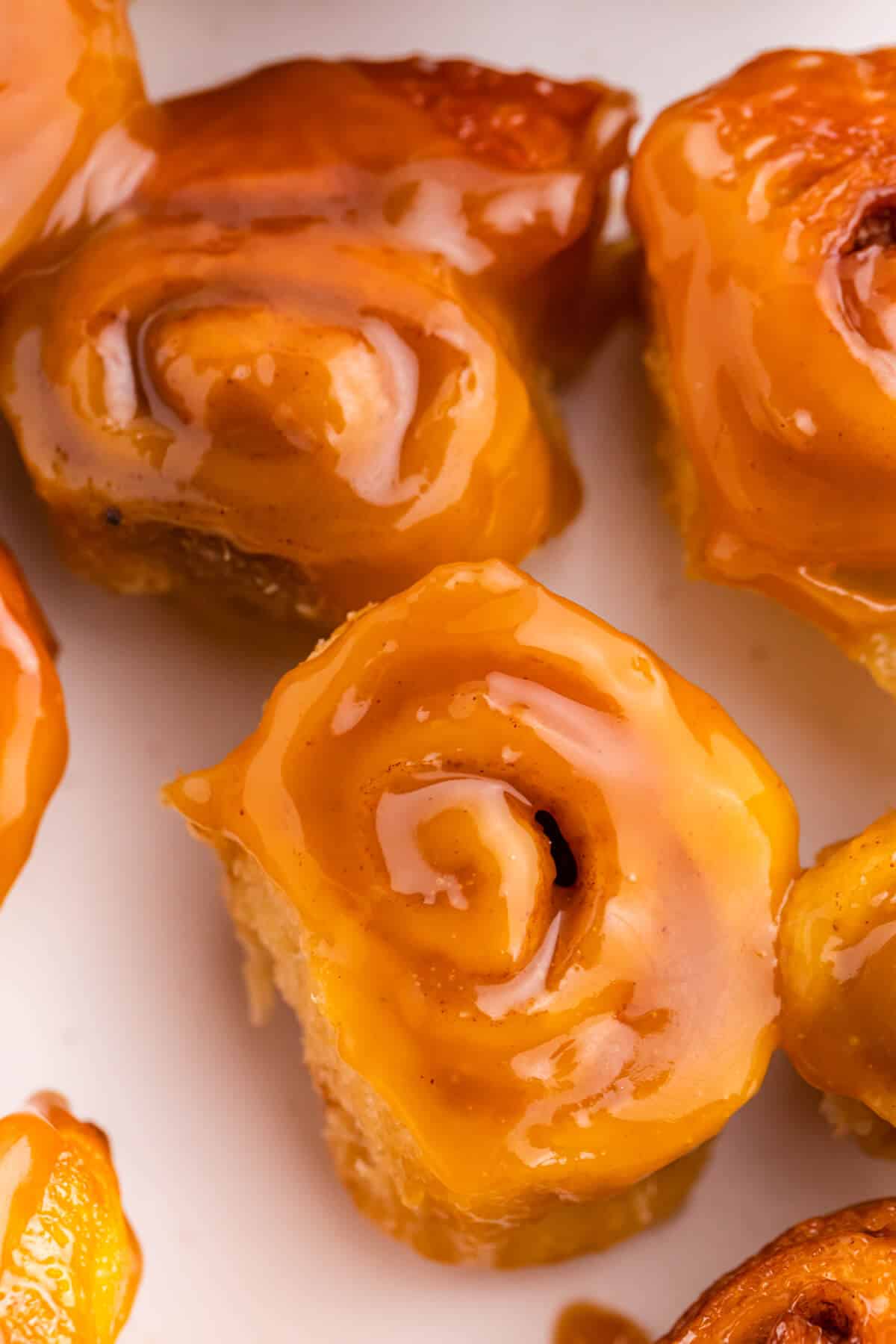 Mini rum butter cinnamon rolls on a plate.