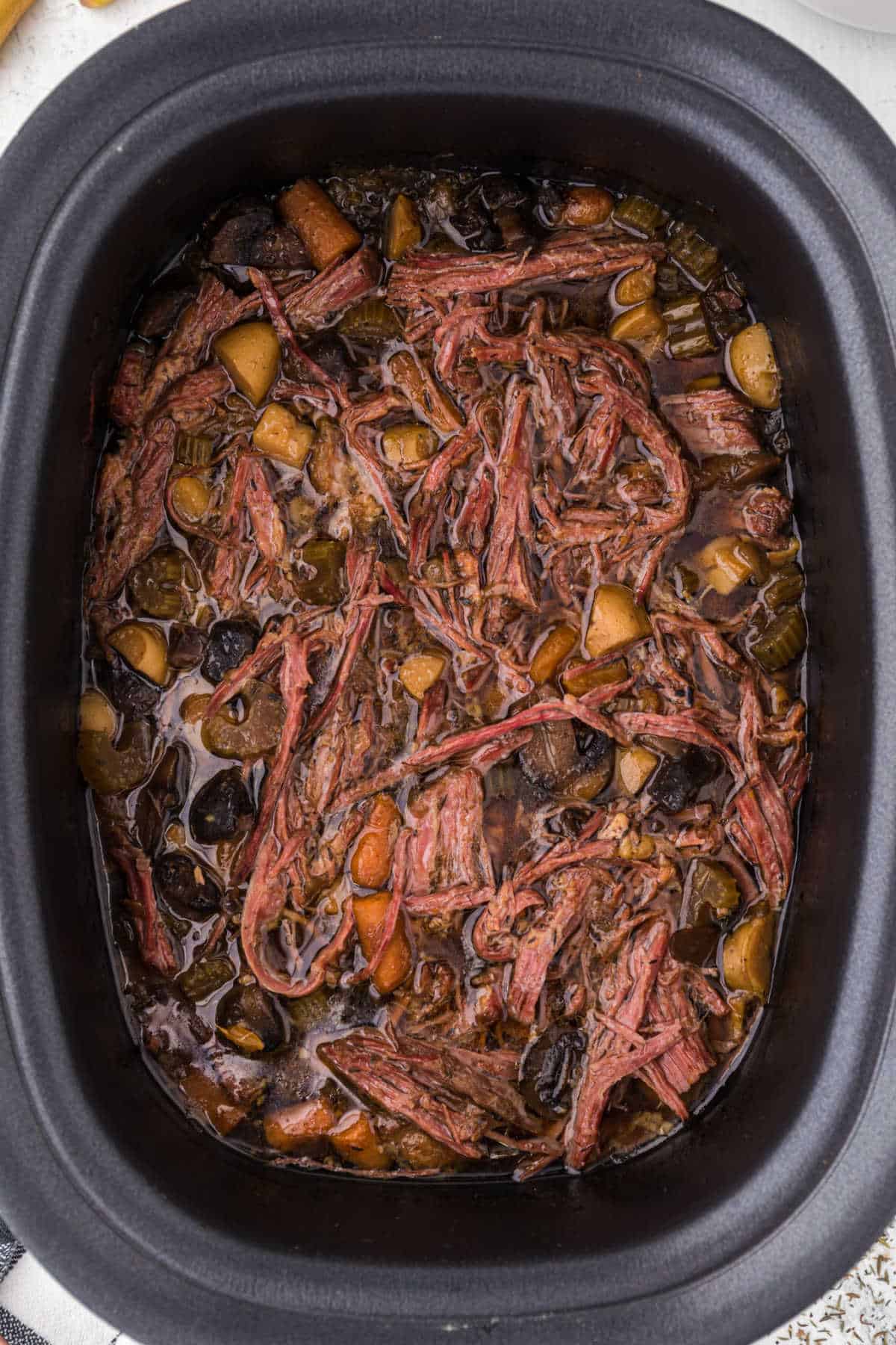 Beef brisket and vegetable soup in a slow cooker.