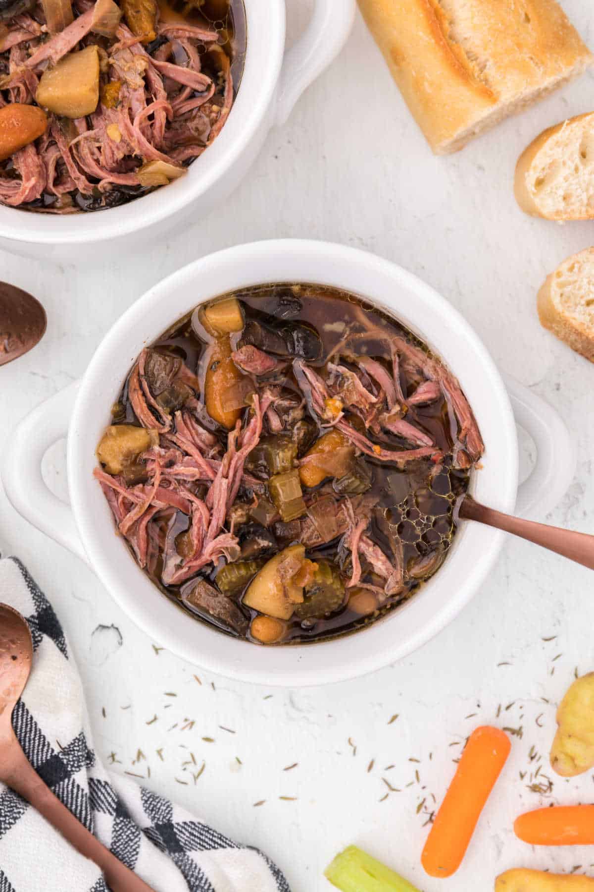 Slow cooker beef brisket and vegetable soup in a bowl with a spoon.