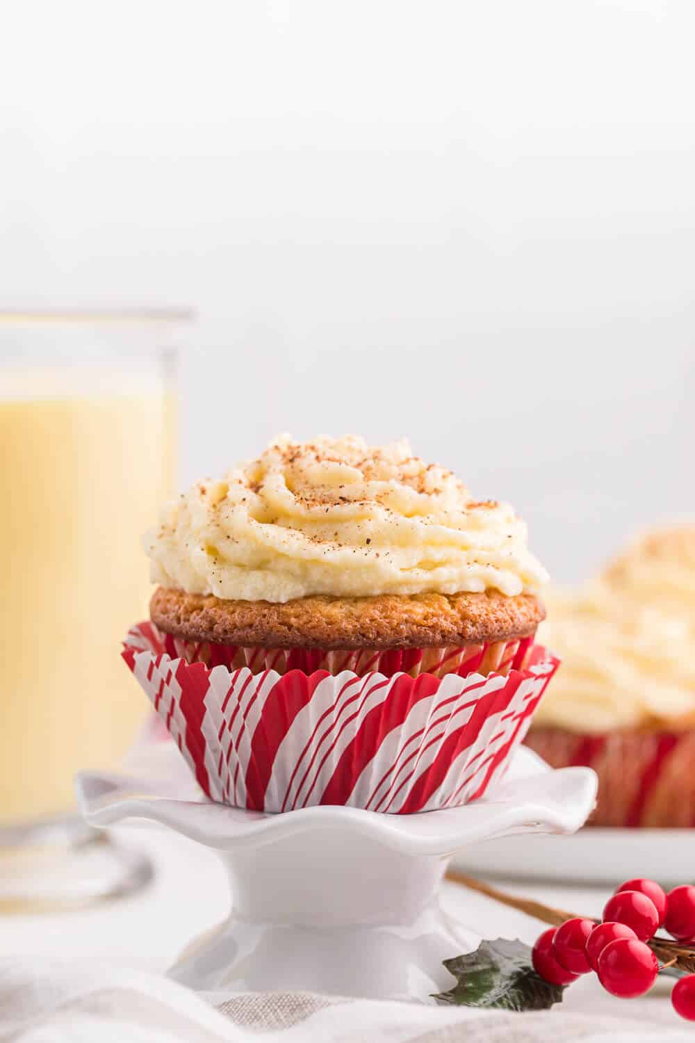 Side shot of eggnog cupcake on a white cupcake stand