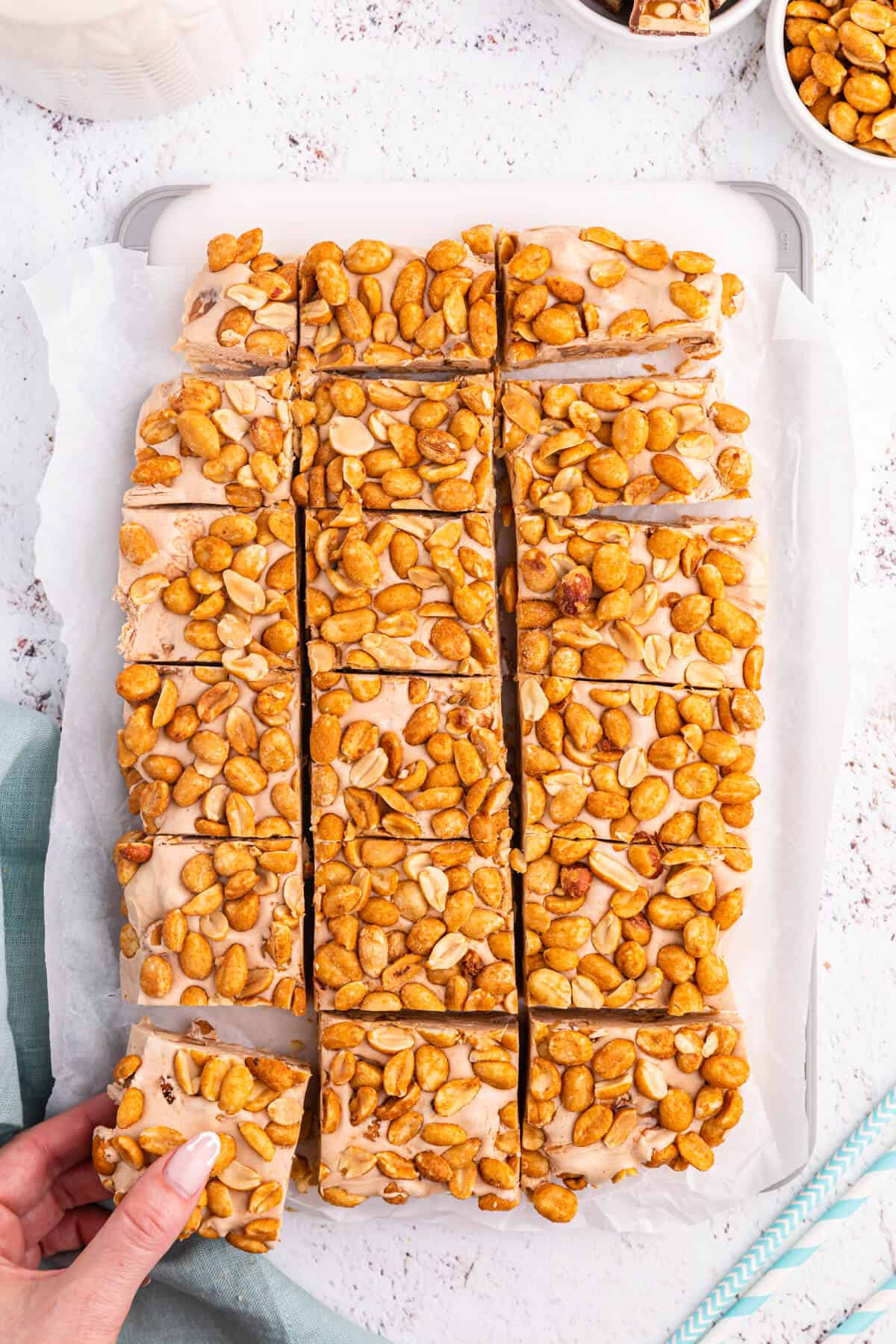 Nougat bars cut into squares with a hand grabbing one.