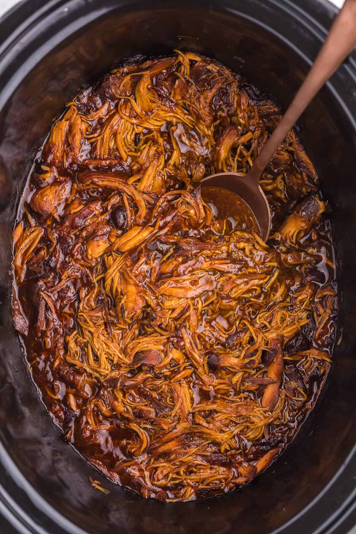 overhead photo of recipe in a crockpot with a serving spoon