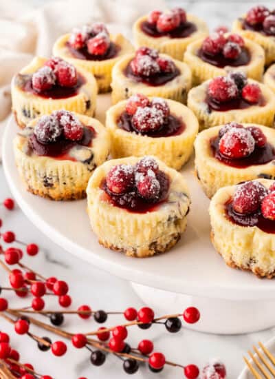 Cranberry white chocolate cheesecake on a platter.