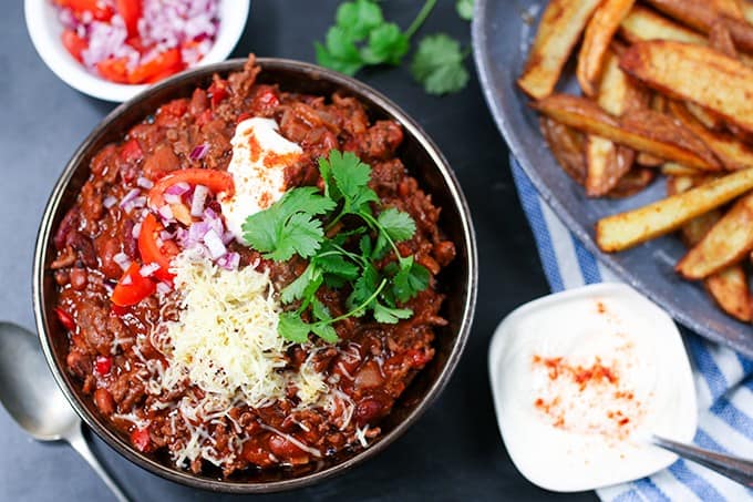 A bowl of chili with toppings.