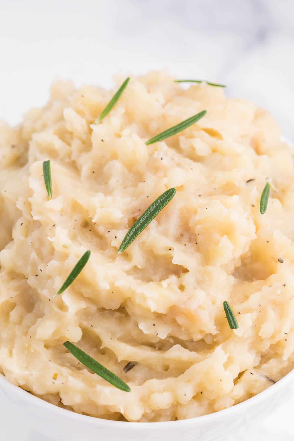 Slow Cooker Rosemary Garlic Mashed Potatoes - Make the creamiest mashed potatoes in your Crockpot! You'll love the rich, garlicky flavor in every bite for a delicious fall side dish.