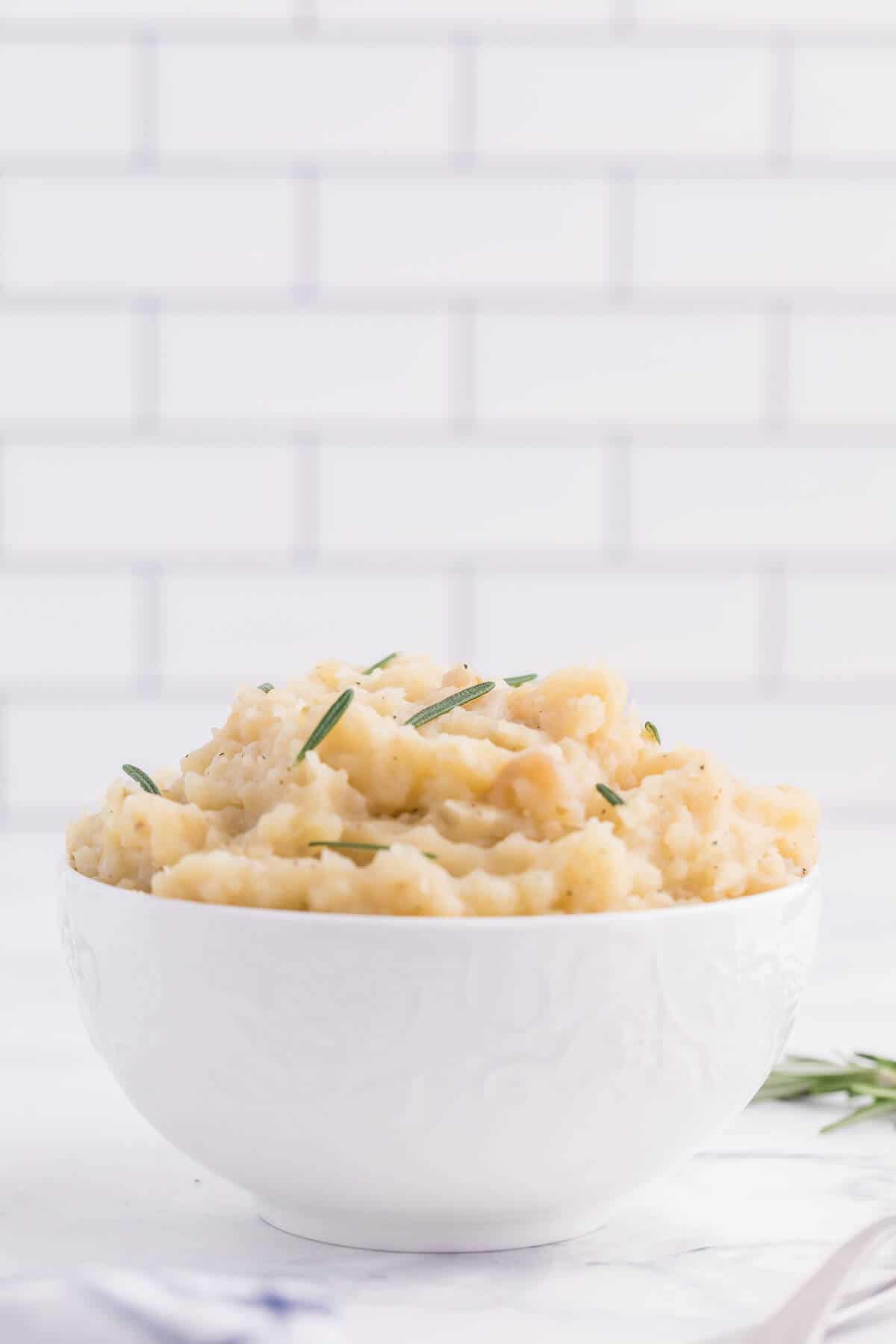 Slow Cooker Rosemary Garlic Mashed Potatoes - Make the creamiest mashed potatoes in your Crockpot! You'll love the rich, garlicky flavor in every bite for a delicious fall side dish.